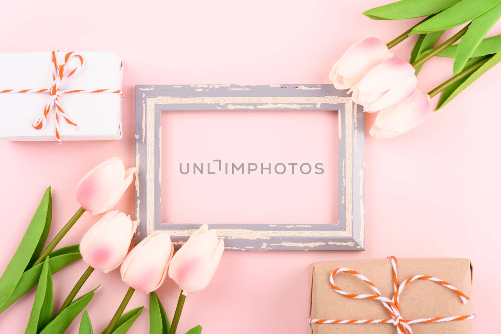 Happy Women's Day, Mother's Day concept. top view flat lay photo frame, gift box and Tulip flower on pink background, copy space for your text