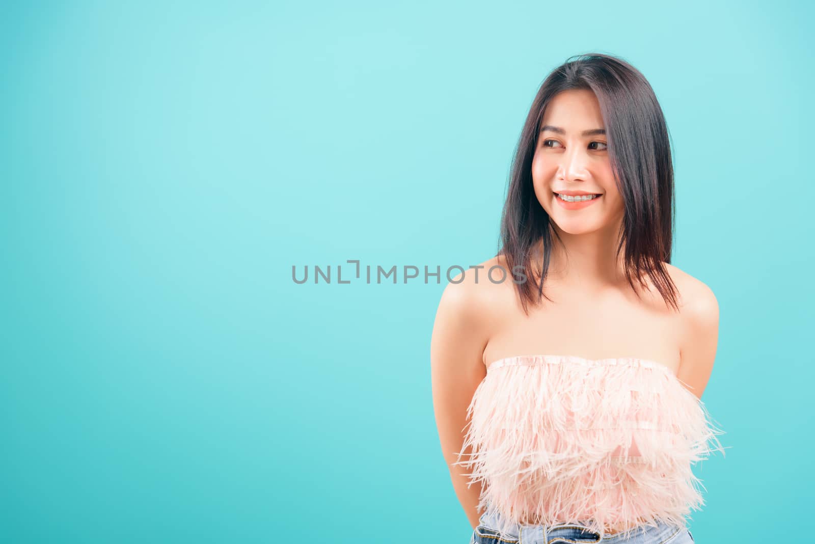 Portrait asian beautiful woman smiling her looking out on blue background, with copy space for text