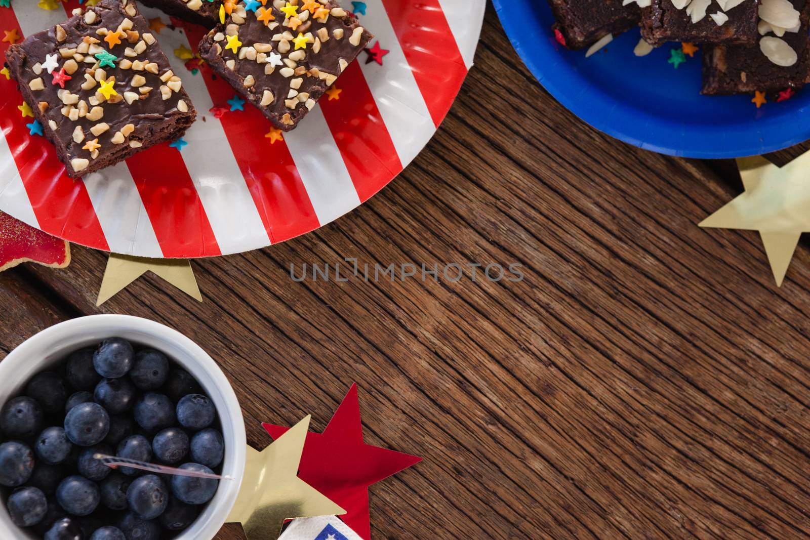 Various sweet foods arranged on wooden table with 4th July theme