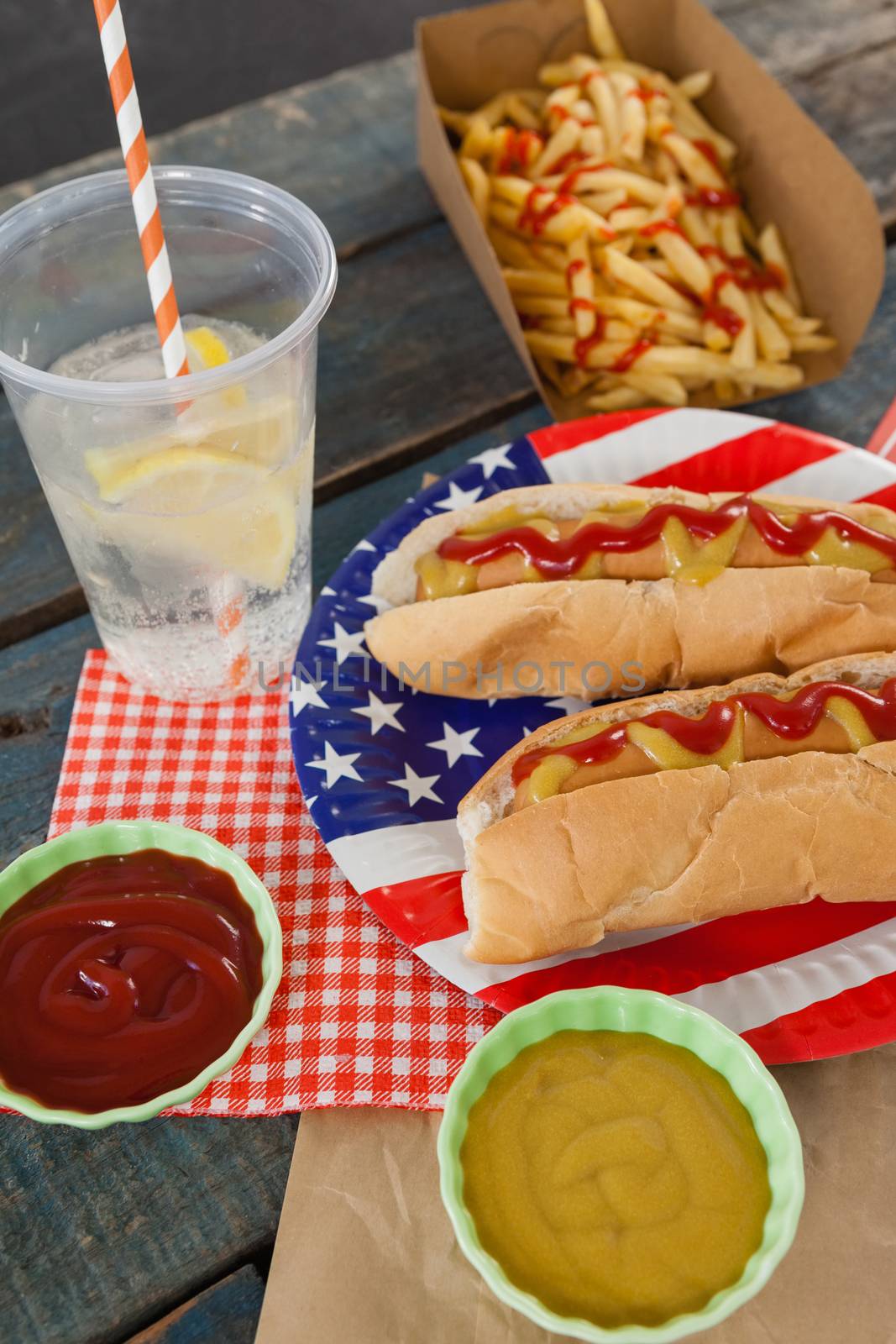 Hot dog served on plate with french fries with 4th july theme