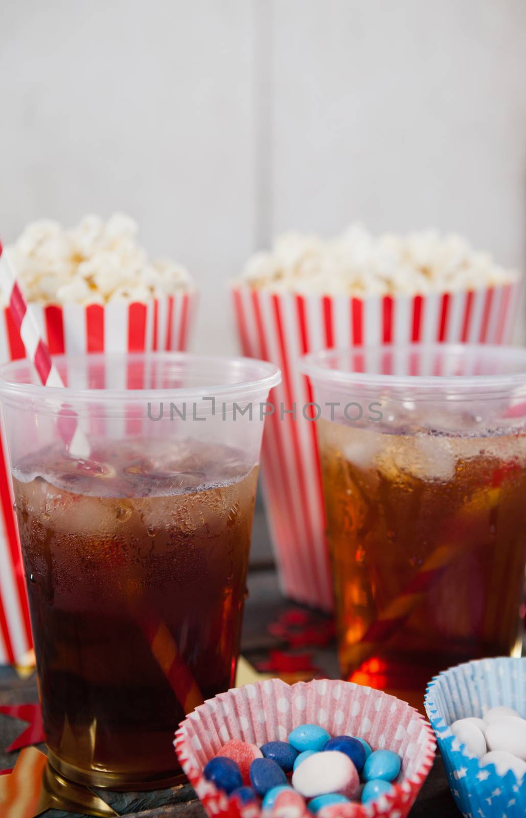 Close-up of popcorn, confectionery and drink with 4th july theme