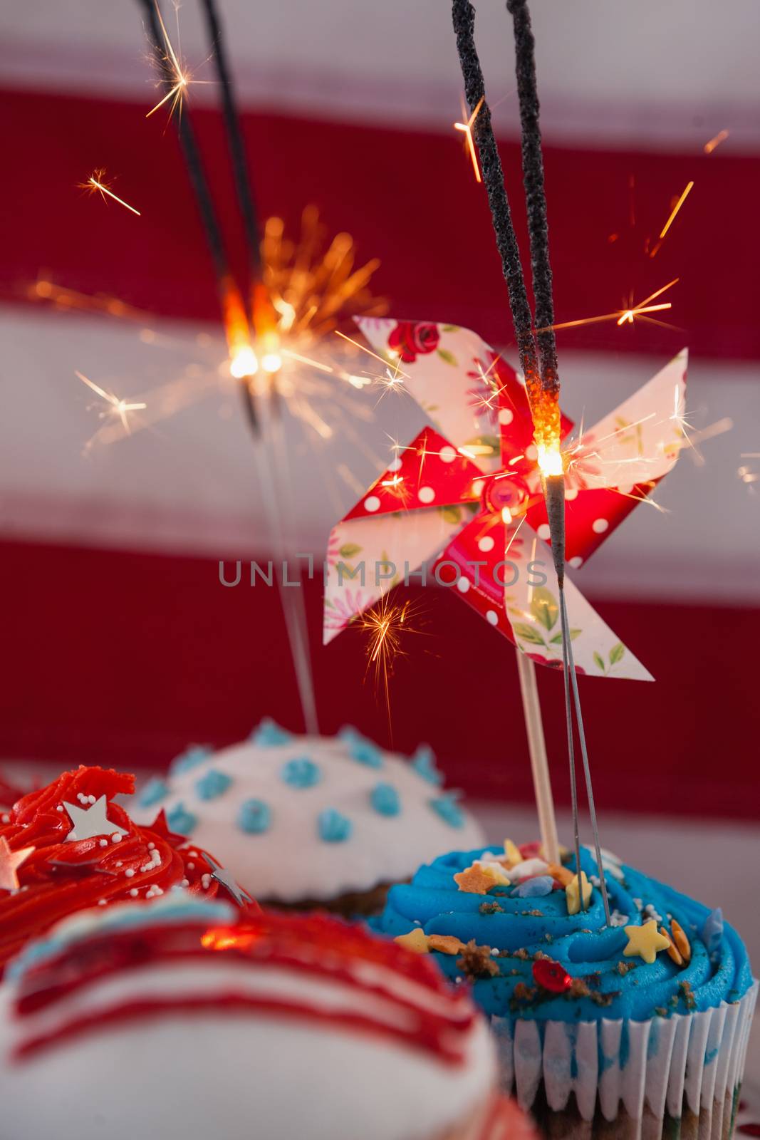 Close-up of burning sparkler on decorated cupcakes with 4th july theme