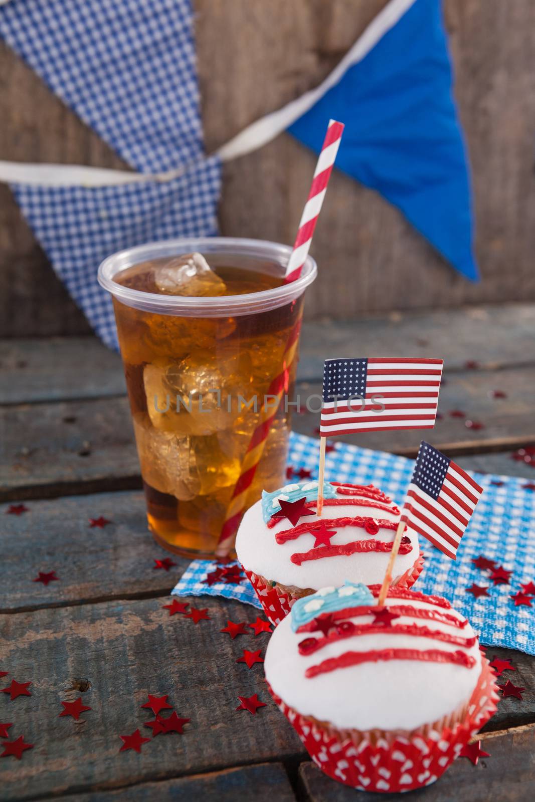 Decorated cupcakes and cold drink with 4th july theme on wooden table