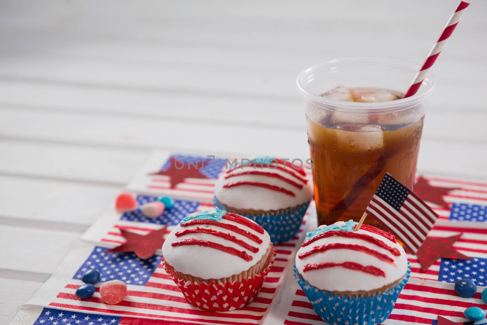 Decorated cupcakes and cold drink with 4th july theme on table