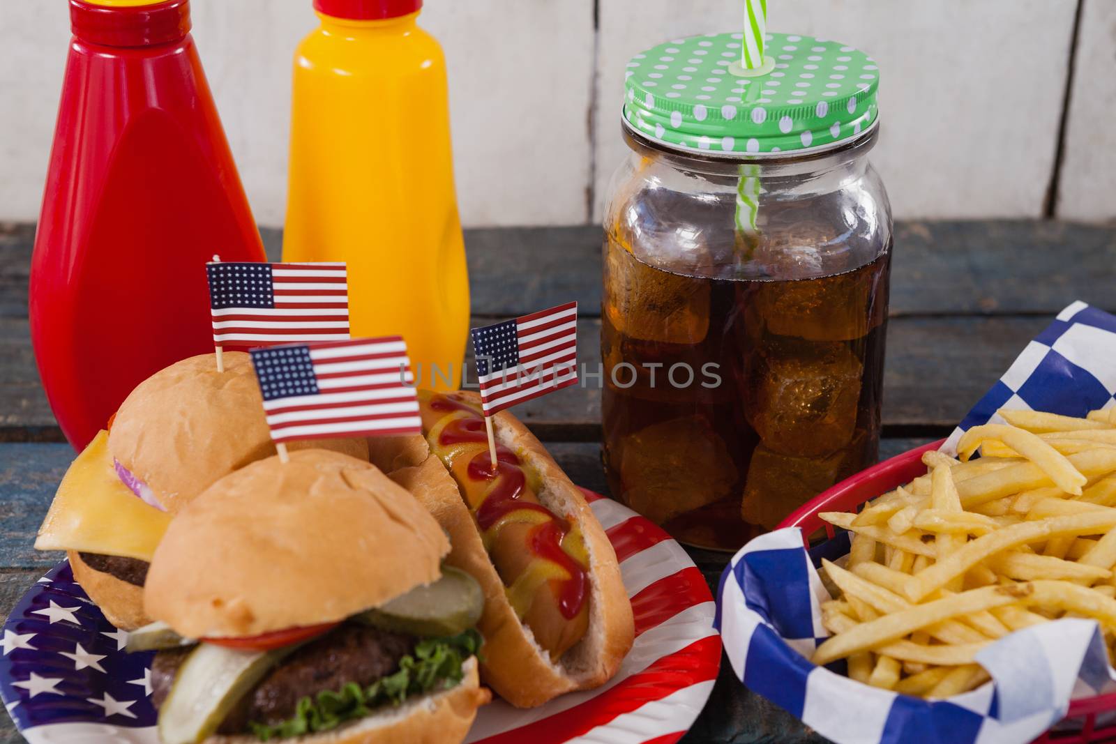 Close-up of snacks and cold drink on wooden table by Wavebreakmedia