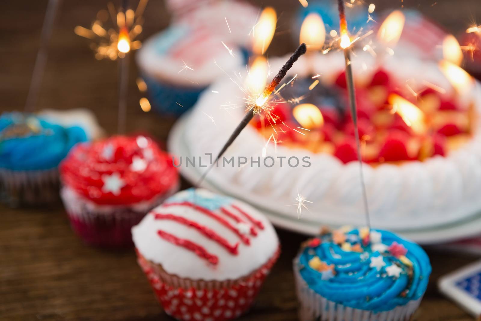 Patriotic 4th of july cake and cupcake arranged on wooden table
