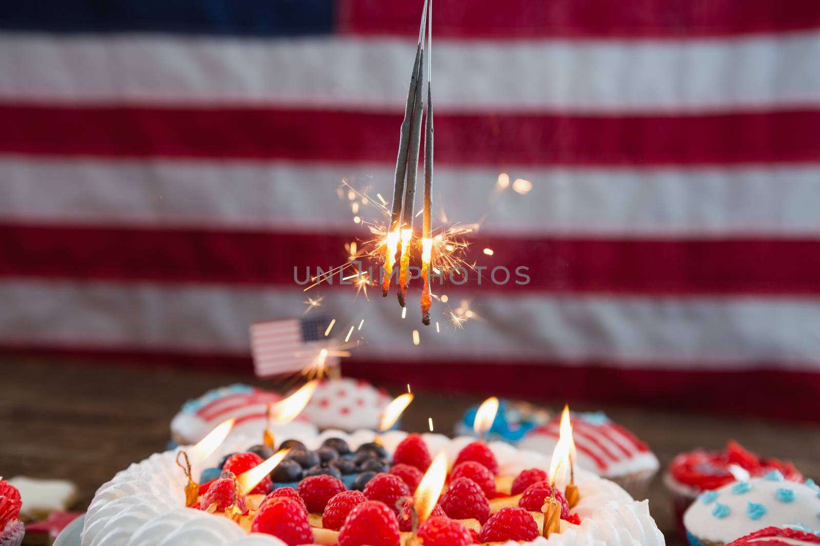 Patriotic 4th of july cake and cupcake arranged on wooden table