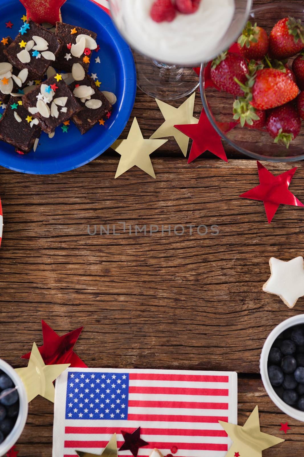 Various sweet foods and fruits arranged on wooden table by Wavebreakmedia