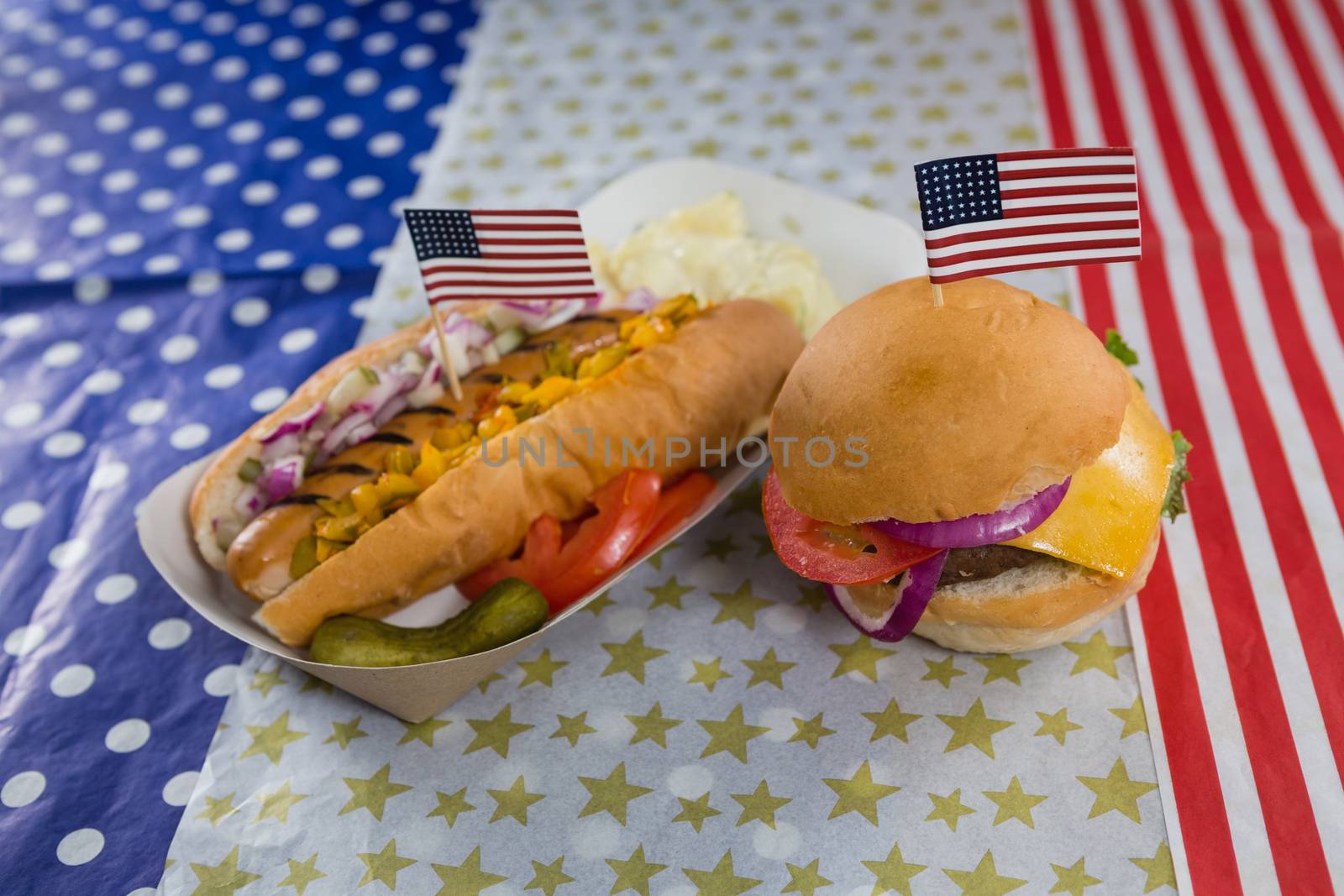 Close-up of burger and hot dog on wooden table with 4th july theme