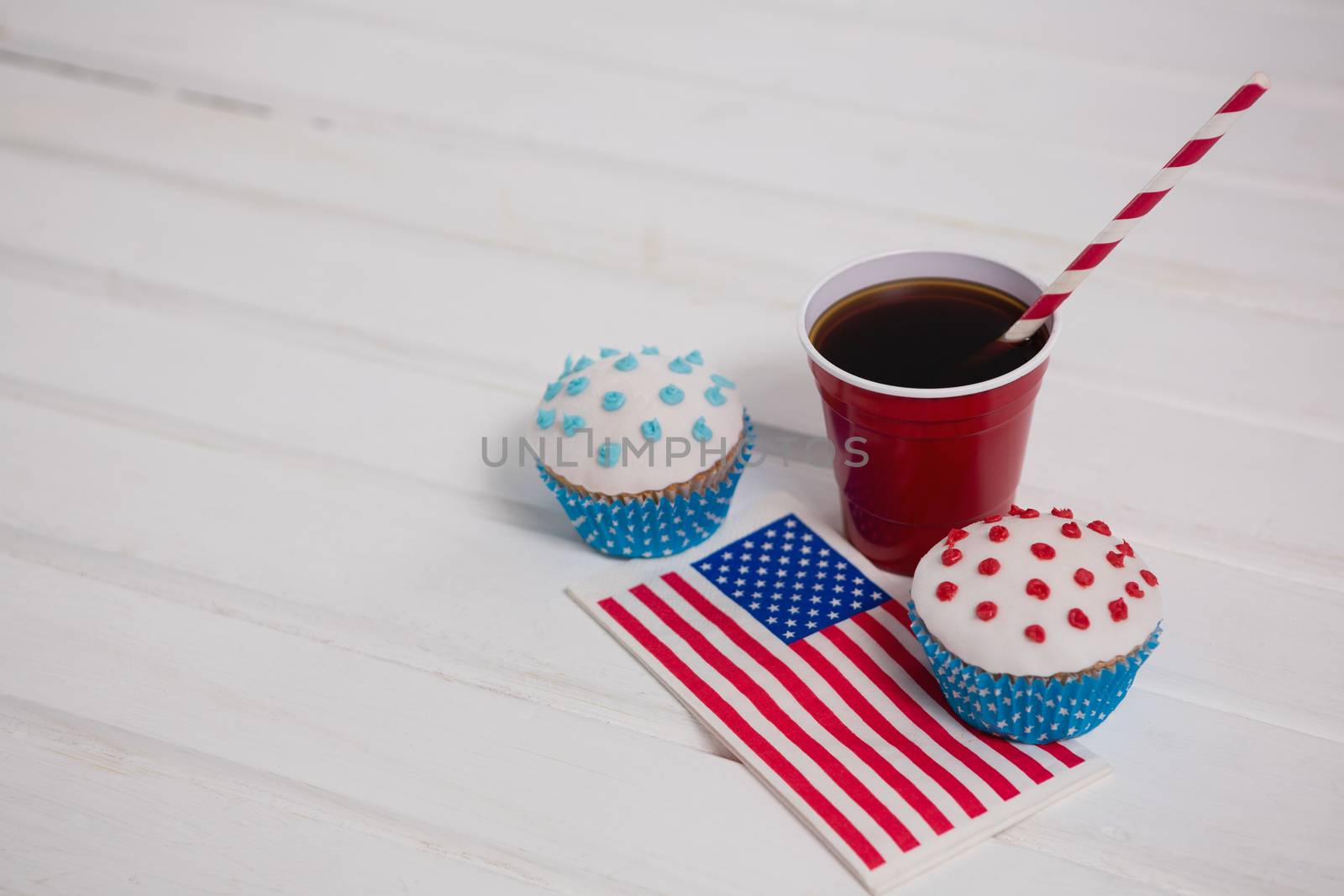 Decorated cupcakes and cold drink with 4th july theme by Wavebreakmedia