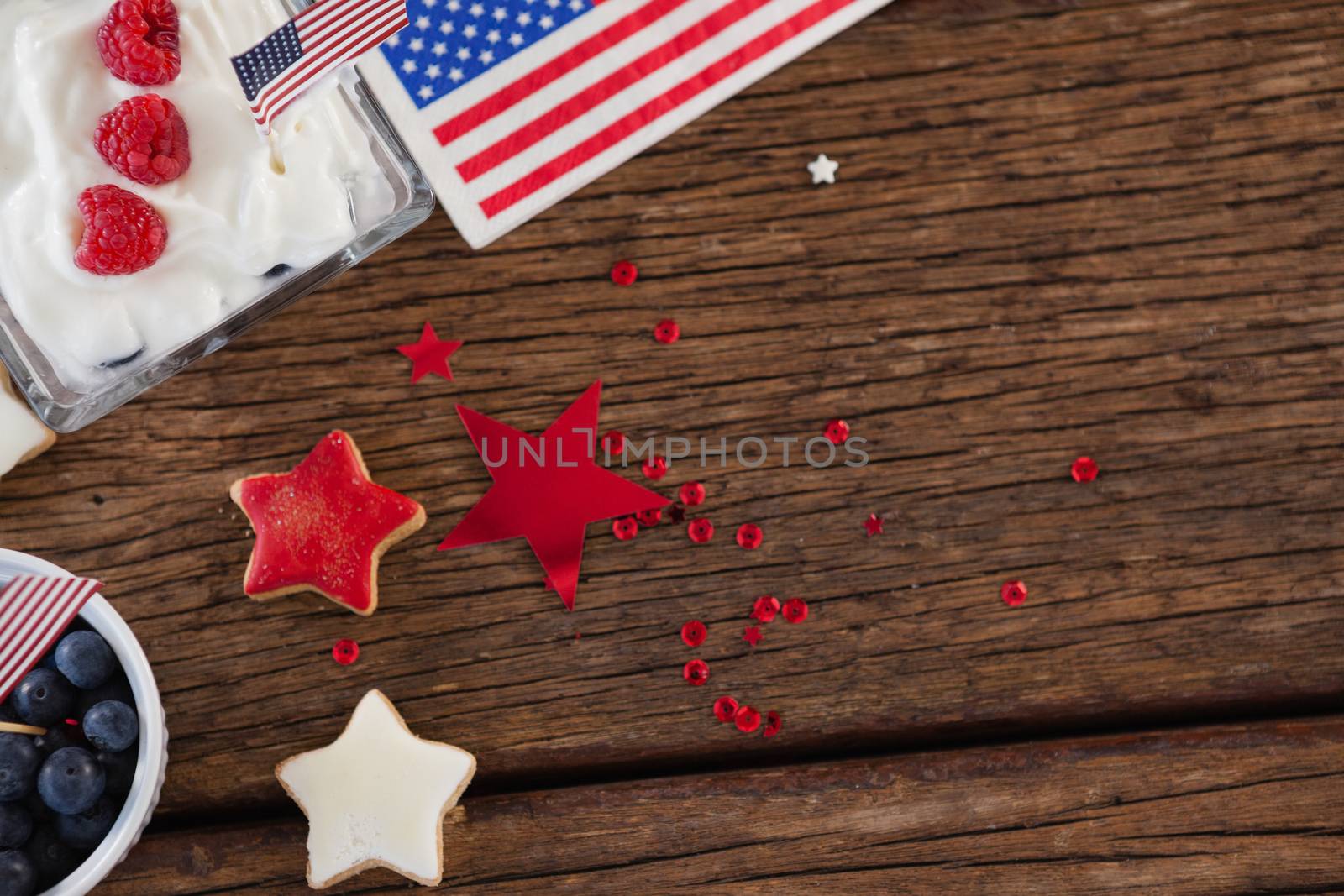 Sweet food and star shape decoration arranged on wooden table with 4th July theme