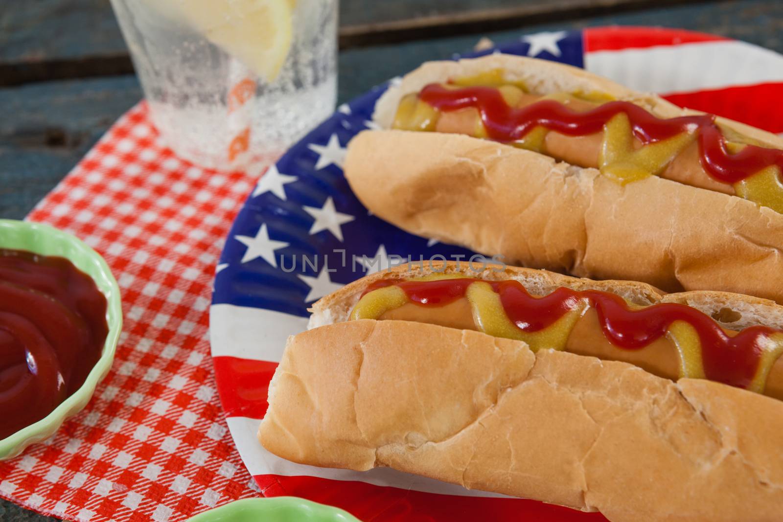 Close-up of hot dog served in plate on wooden table with 4th July theme