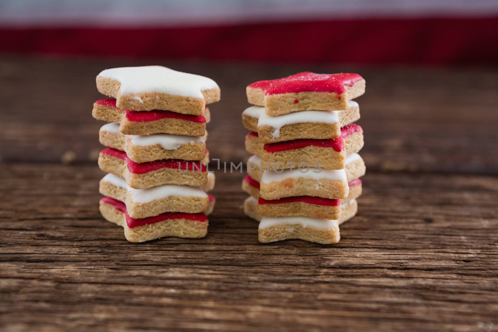 Red and white sugar cookies stacked on wooden table by Wavebreakmedia