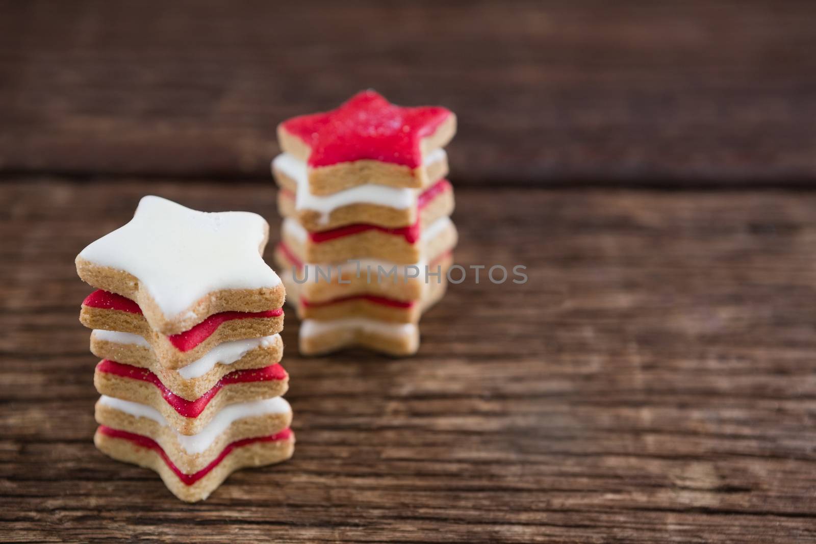 Red and white sugar cookies stacked on wooden table for 4th of July