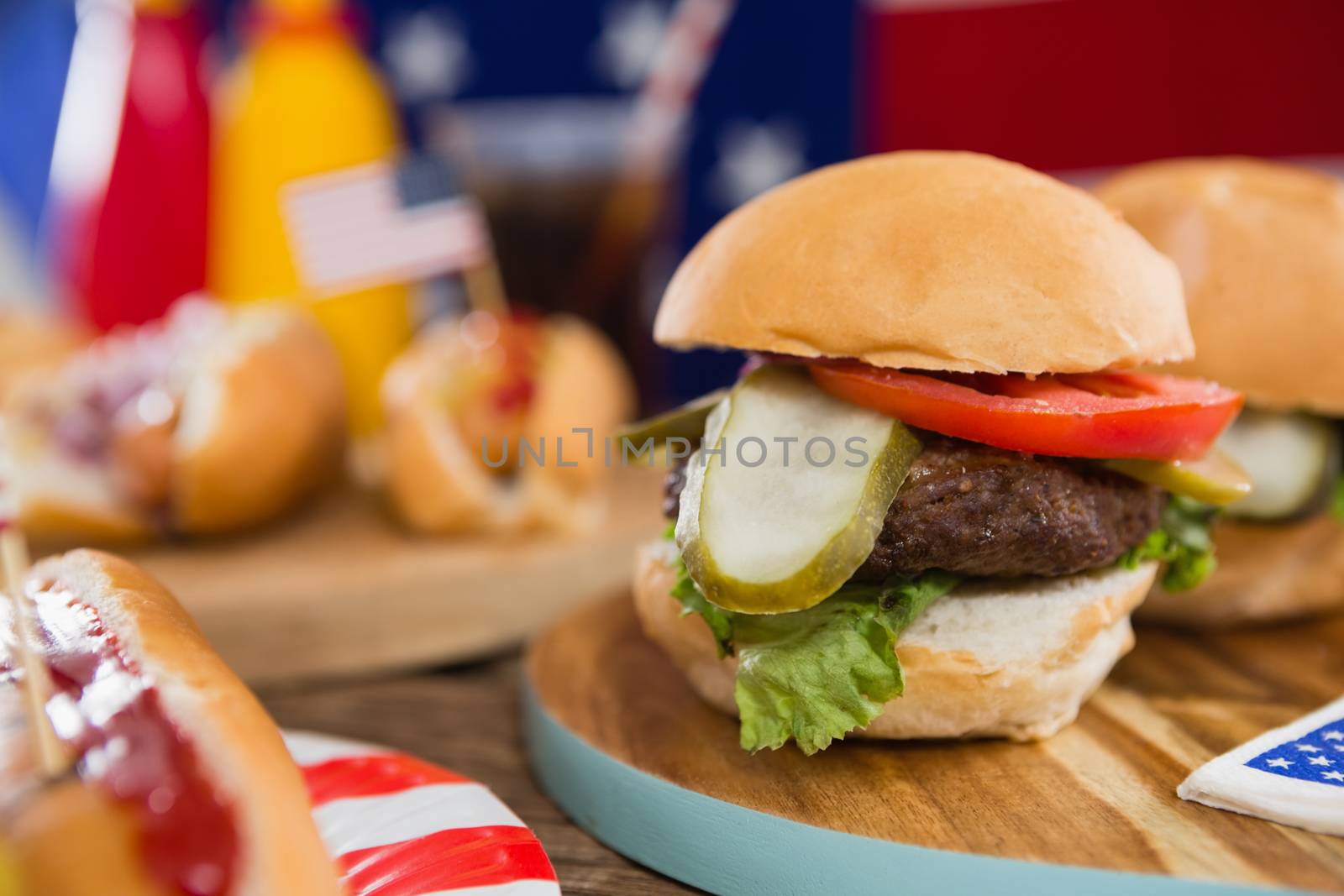 Burgers on wooden table with 4th july theme by Wavebreakmedia
