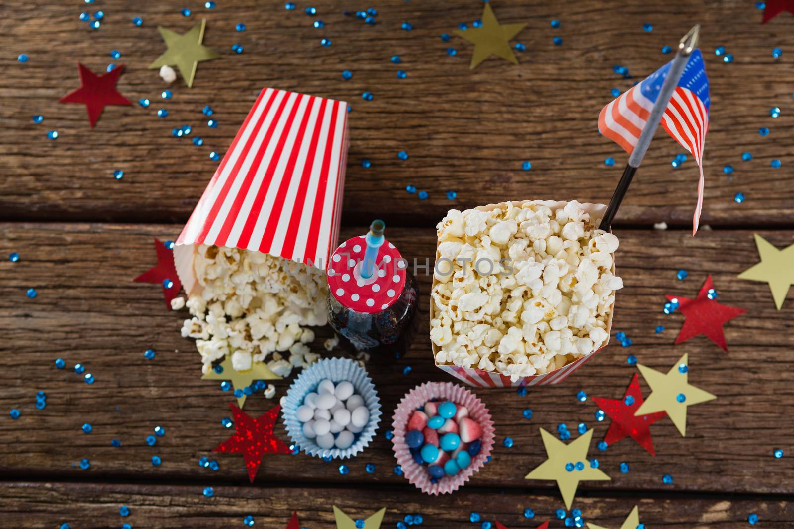 Popcorn, sweet food and cold drink decorated with 4th july theme on wooden table