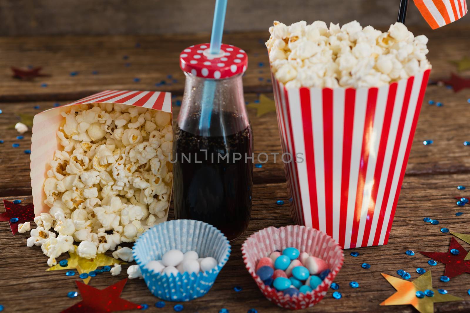 Popcorn, sweet food and cold drink decorated with 4th july theme by Wavebreakmedia