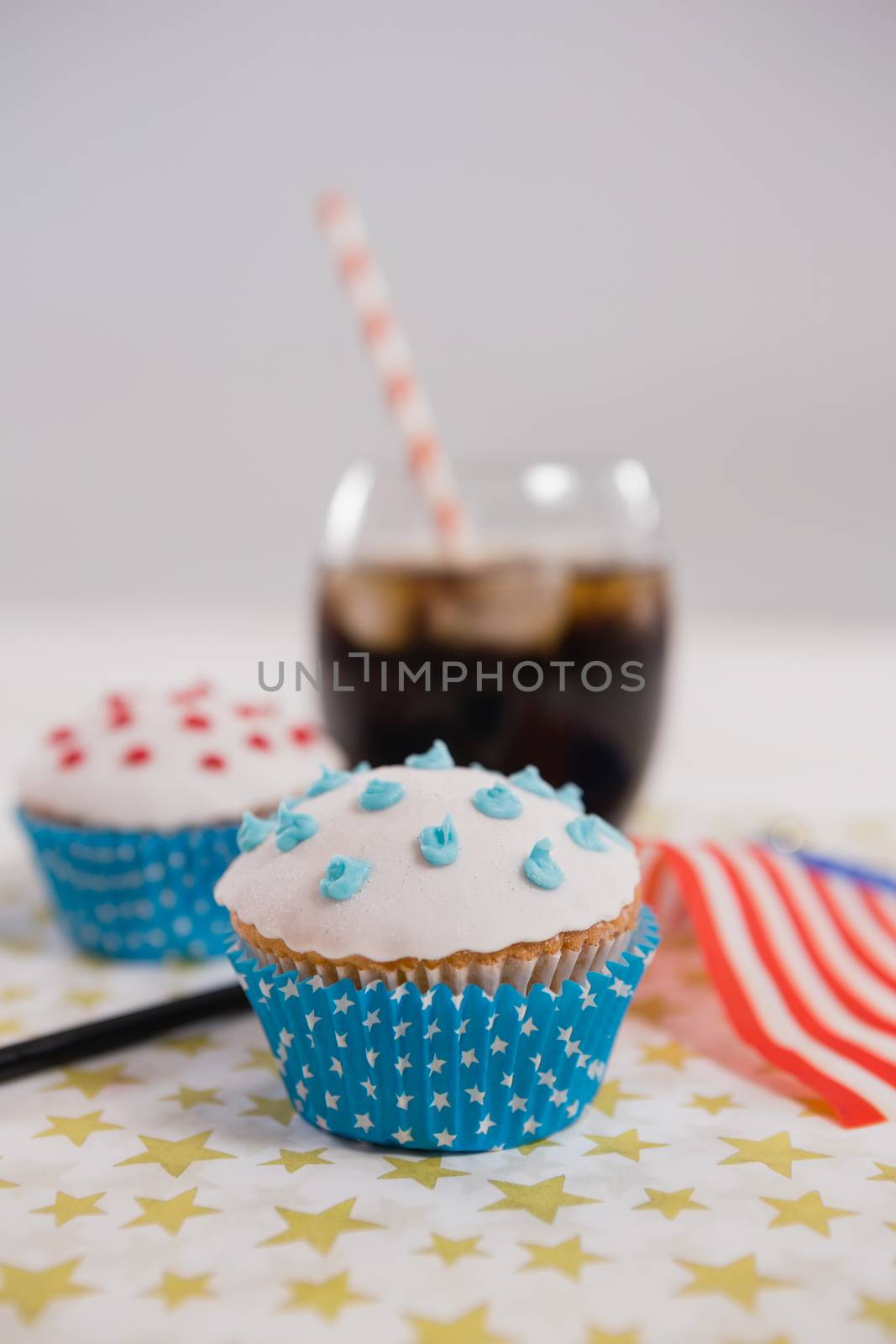 Close-up of drink and cupcake with 4th july theme on table