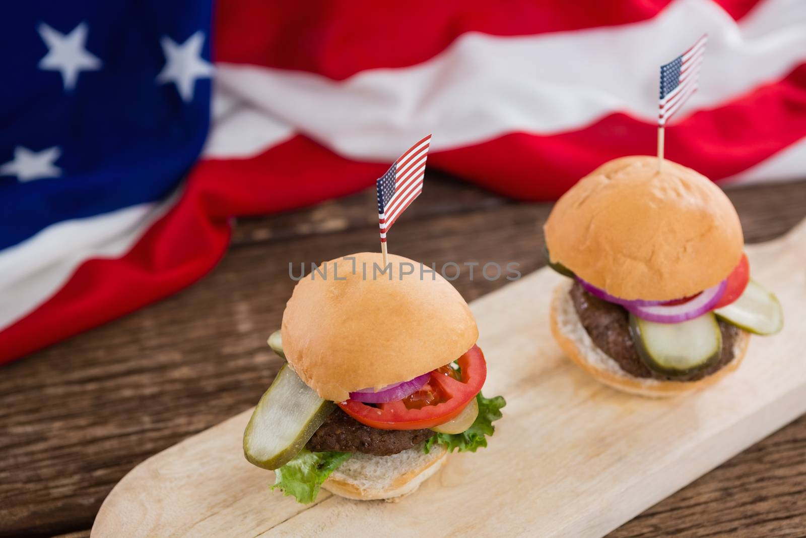Burgers arranged on wooden board with 4th july theme