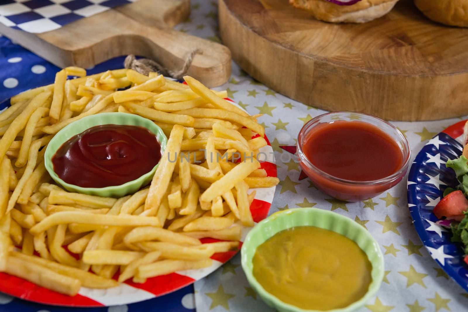French fries on wooden table with 4th july theme by Wavebreakmedia