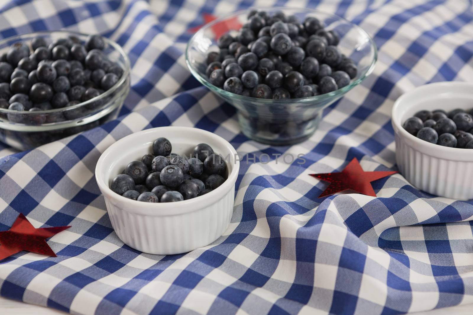 Black berries in bowls with 4th july theme on wooden table