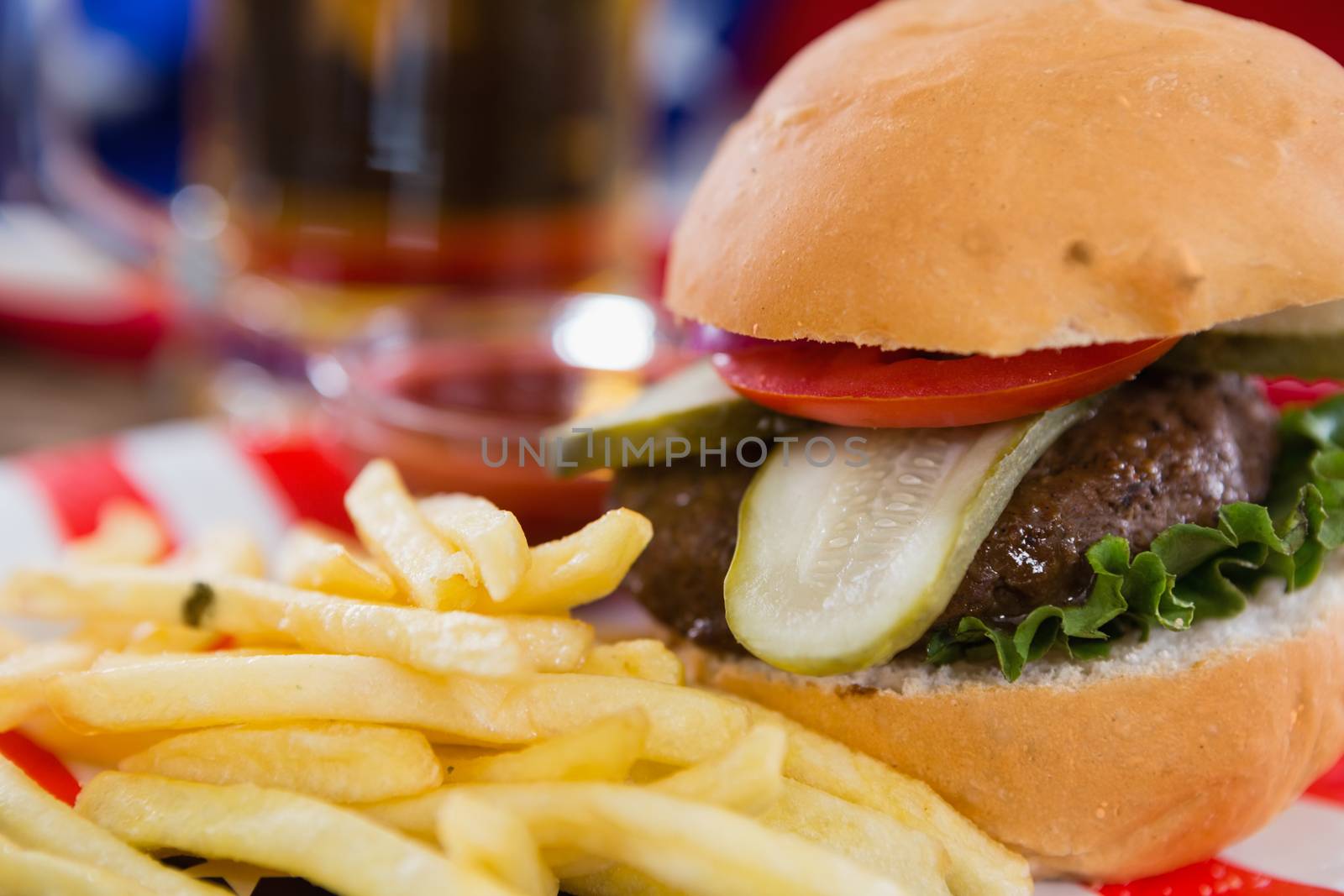Close-up of burger and french fries on wooden table with 4th july theme