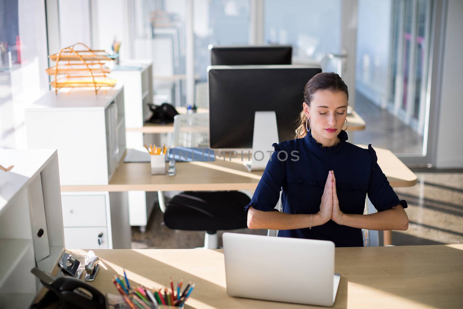 Female executive doing yoga in office