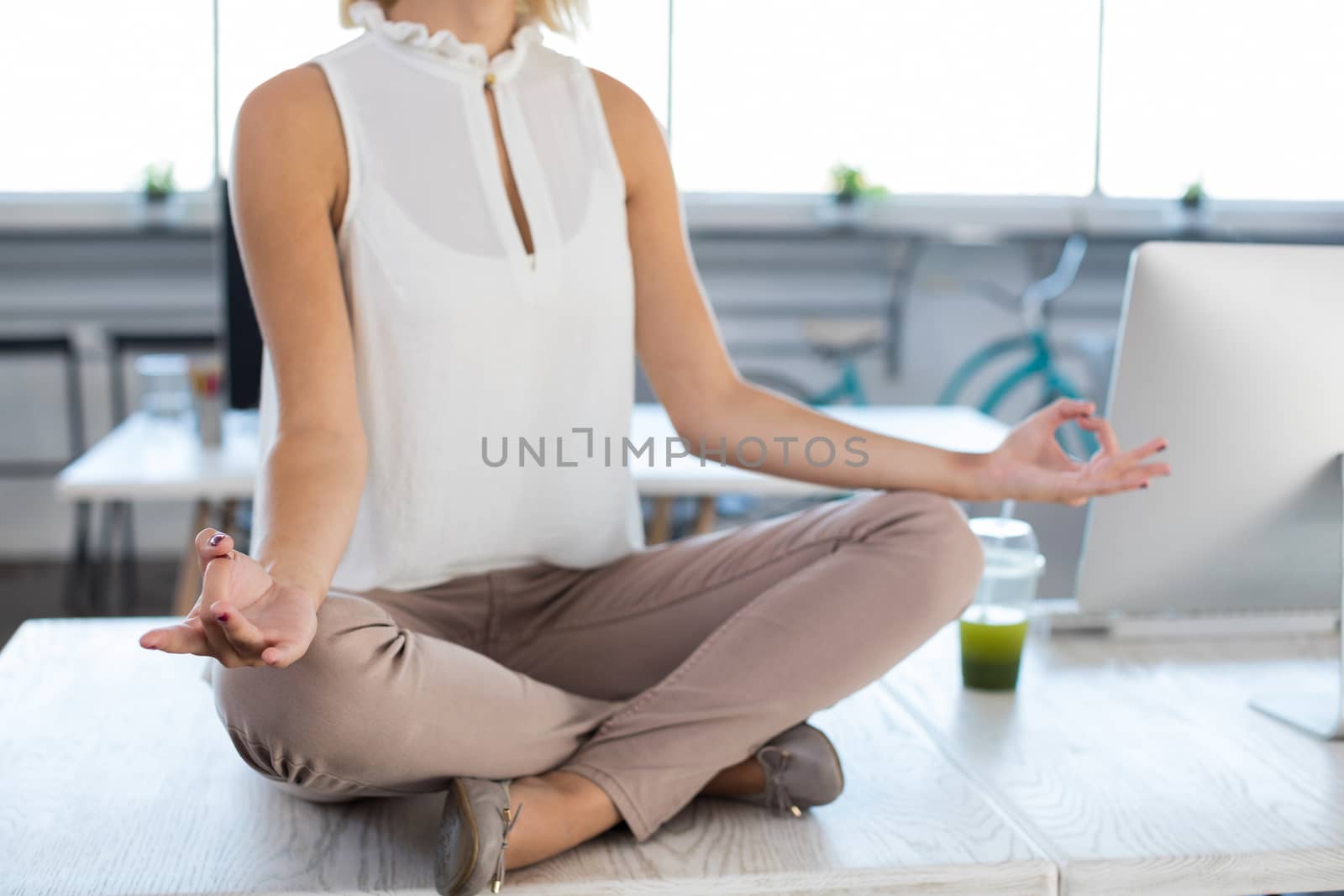 Female executives doing yoga in office by Wavebreakmedia