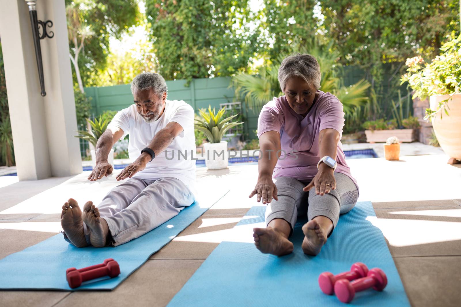 Senior couple doing stretching exercise by Wavebreakmedia