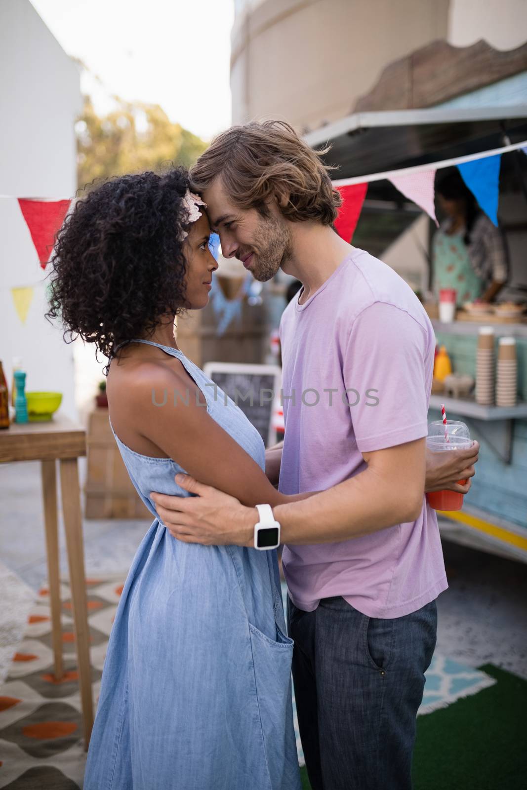 Romantic couple embracing each other near food truck