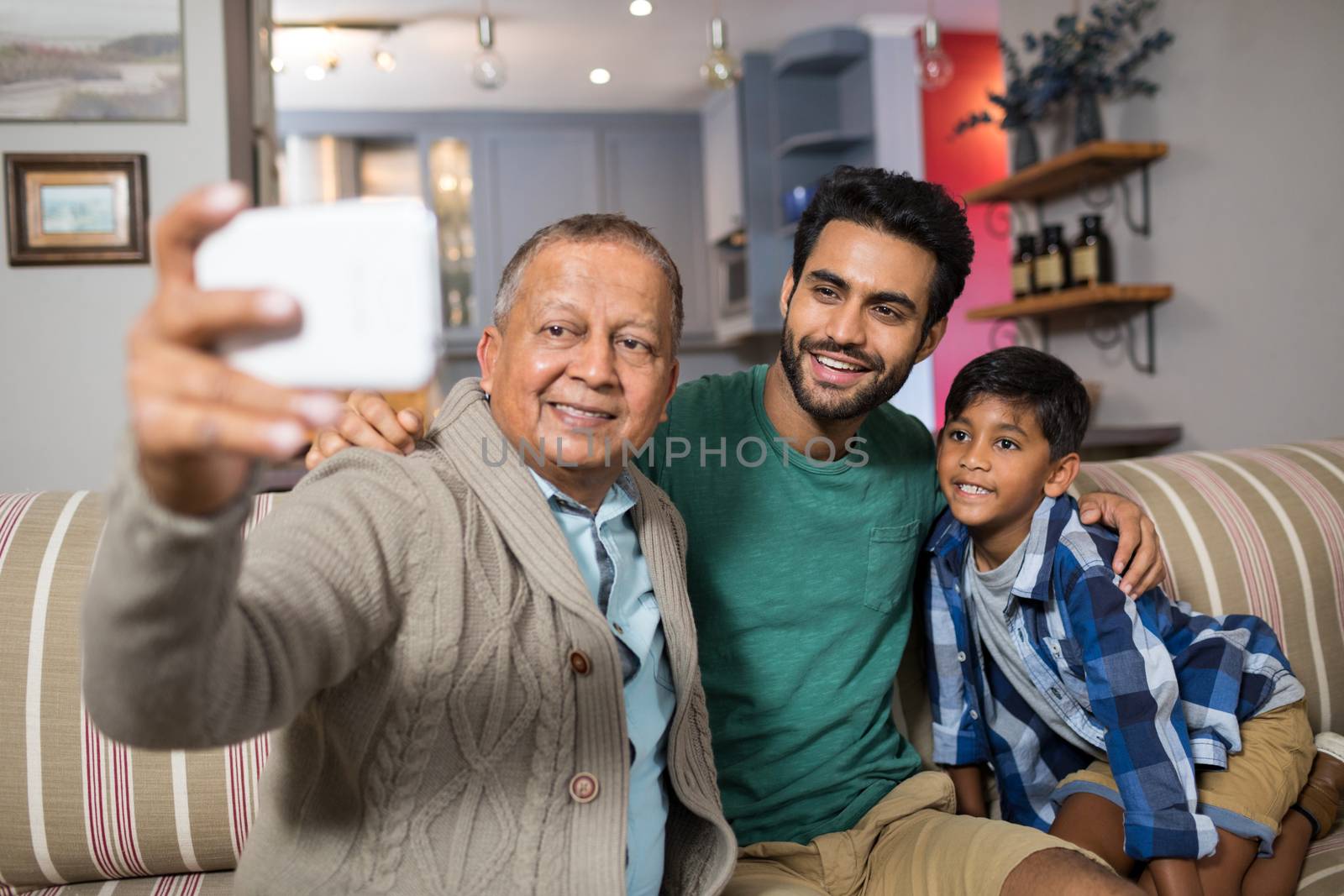 Family taking selfie while sitting on sofa at home
