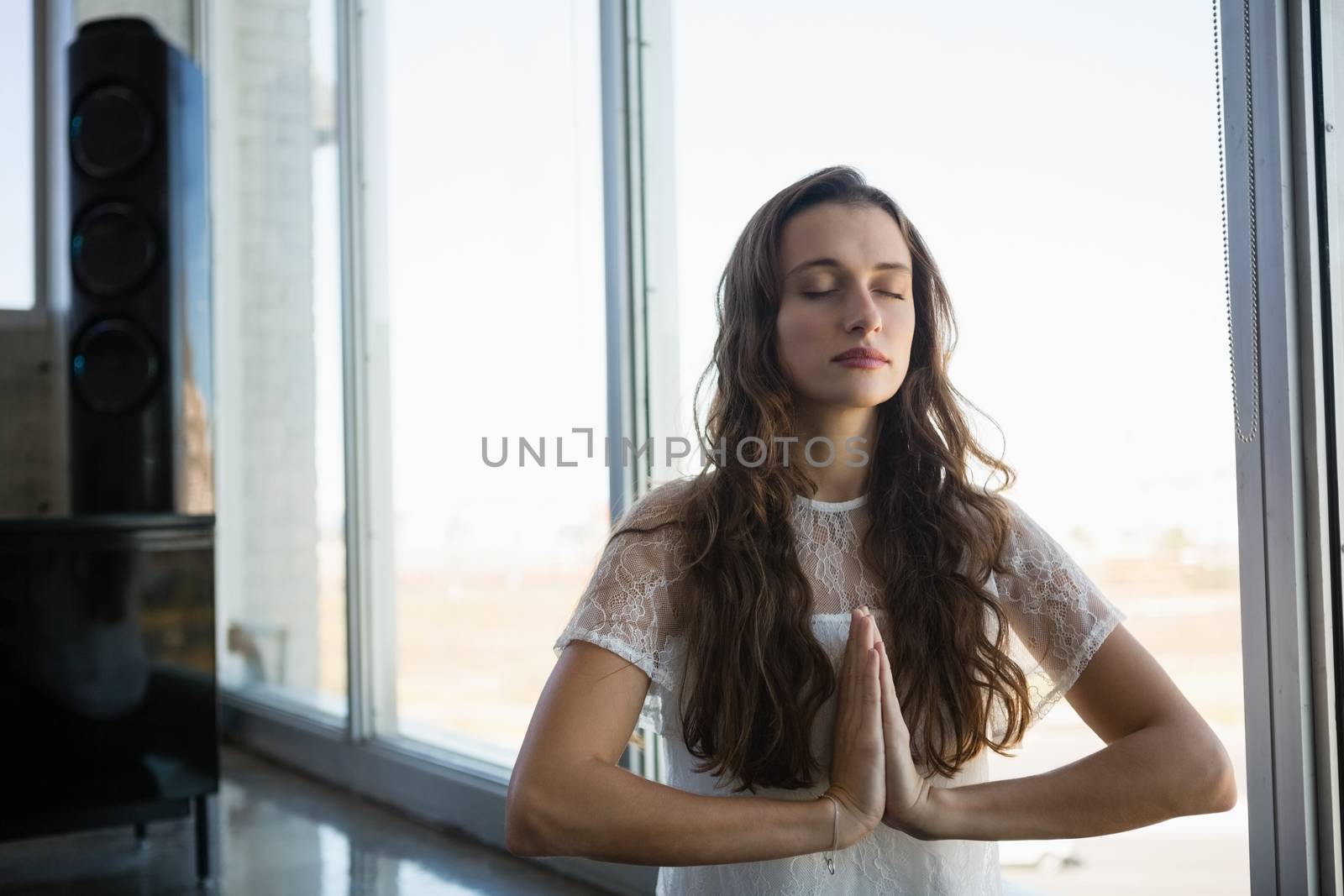 Young woman doing yoga at office by Wavebreakmedia