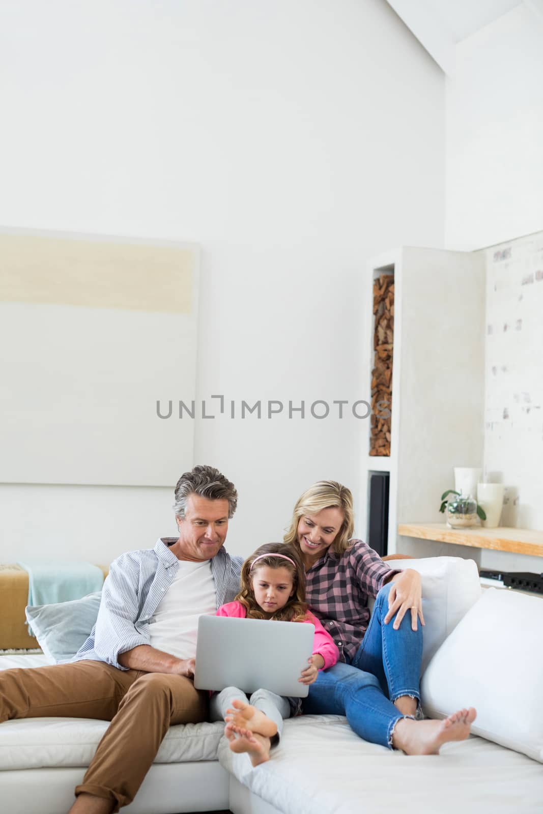 Family using laptop together in living room at home