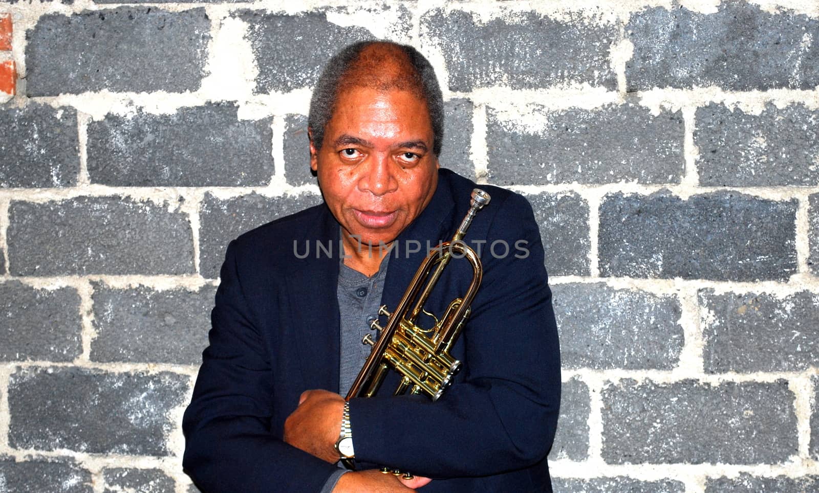 African american jazz trumpet player with his horn in studio basement.