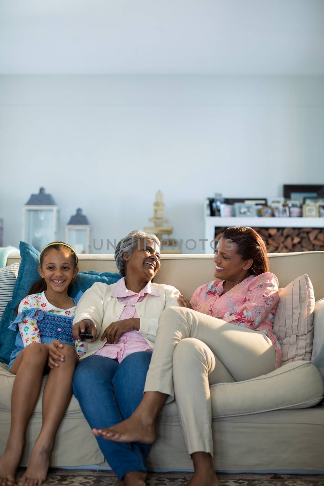 Smiling family watching television together in living room by Wavebreakmedia