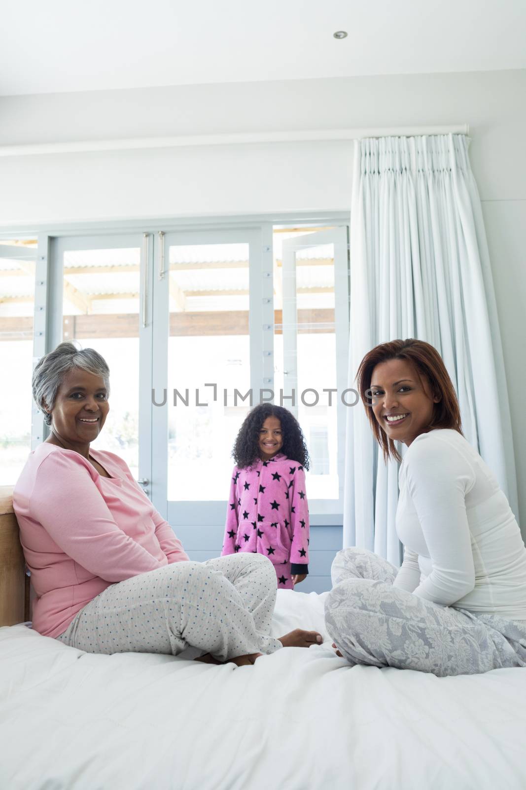 Portrait of happy family relaxing in bed room at home