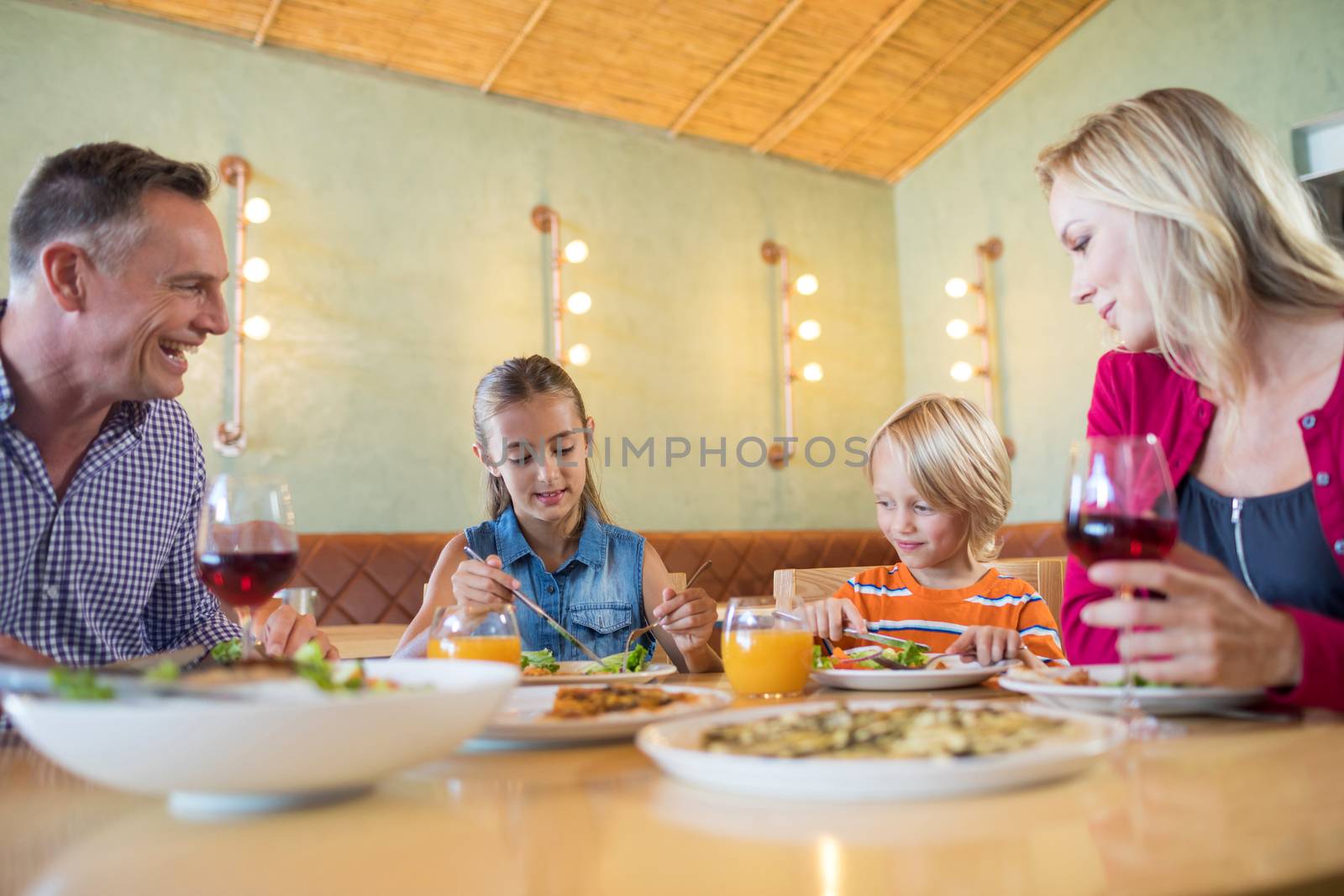 Family having dinner at restaurant by Wavebreakmedia