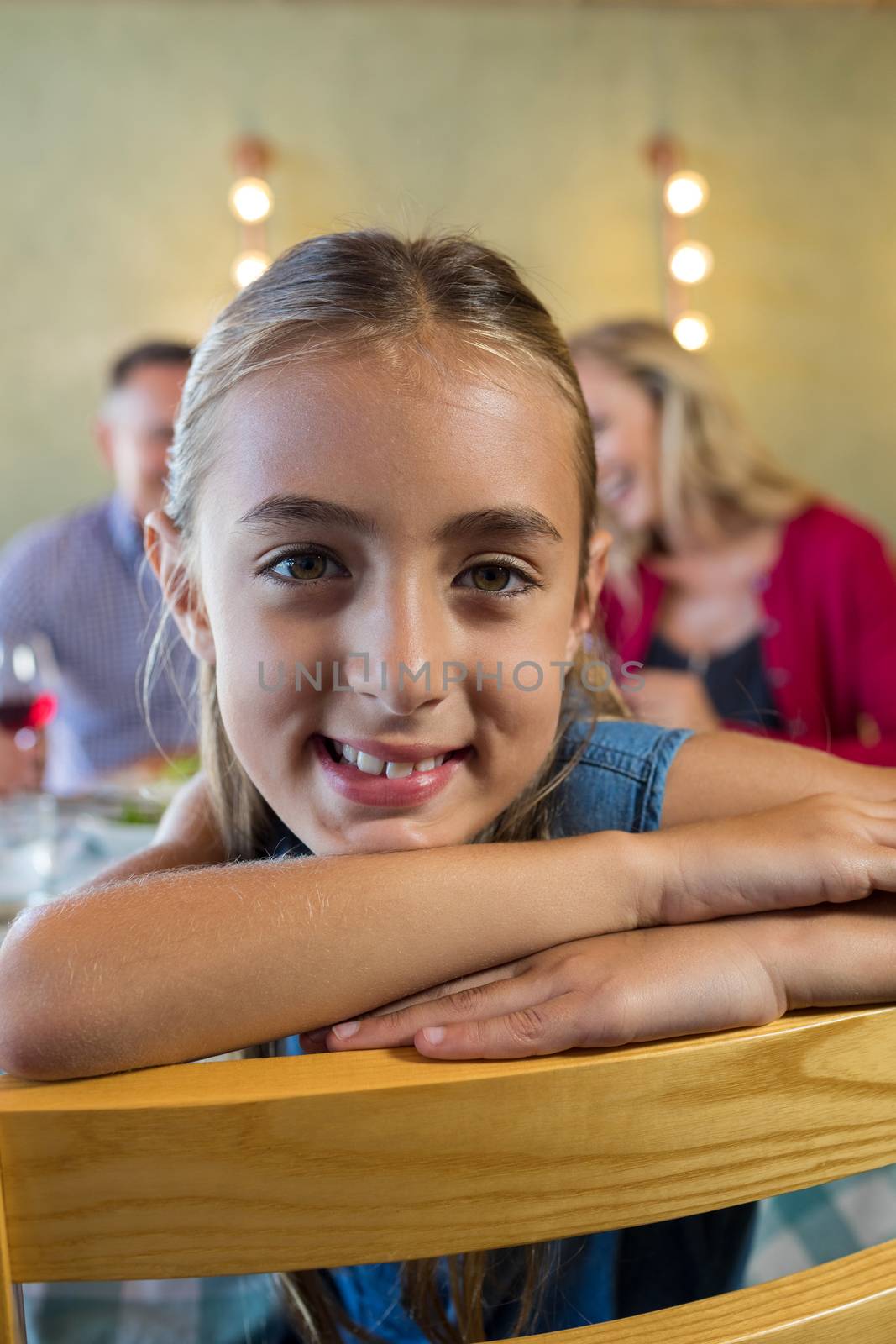 Close up portrait of smiling girl with family in background by Wavebreakmedia