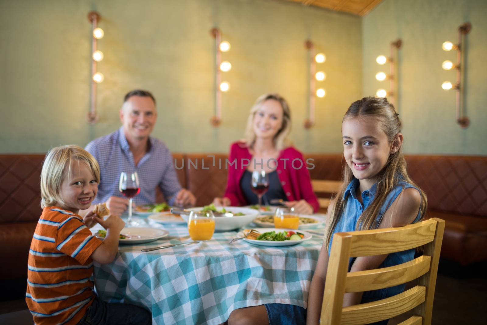 Portrait of happy family in restaurant by Wavebreakmedia