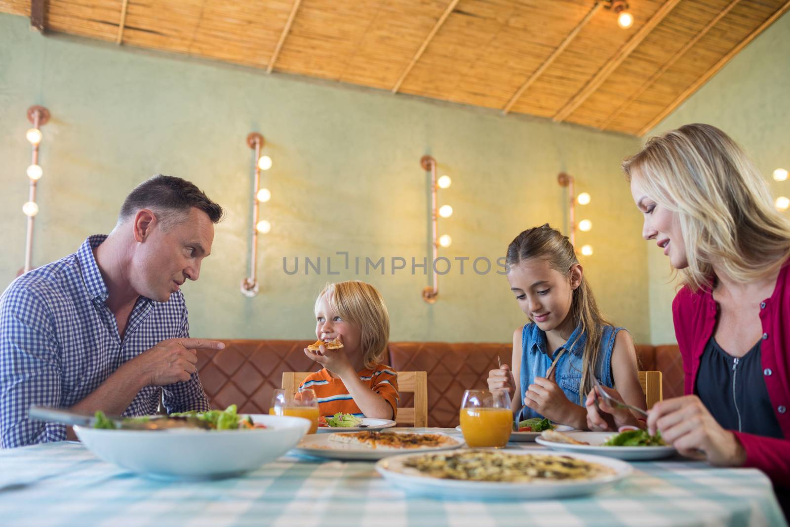 Smiling family having food at restaurant