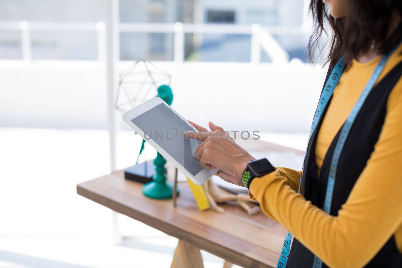 Fashion designer using digital tablet in office by Wavebreakmedia