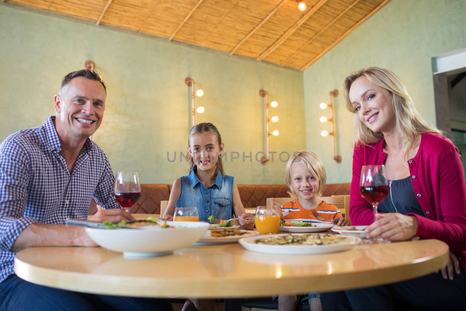 Portrait of happy family having dinner at restaurant