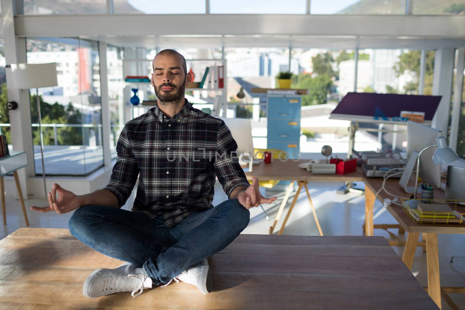 Male executive doing yoga in office by Wavebreakmedia