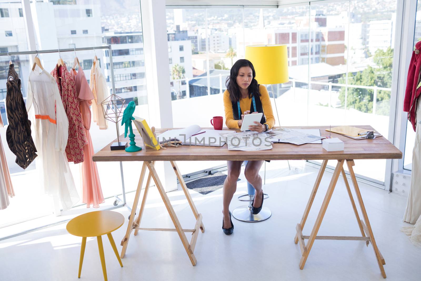 Fashion designer using digital tablet in office