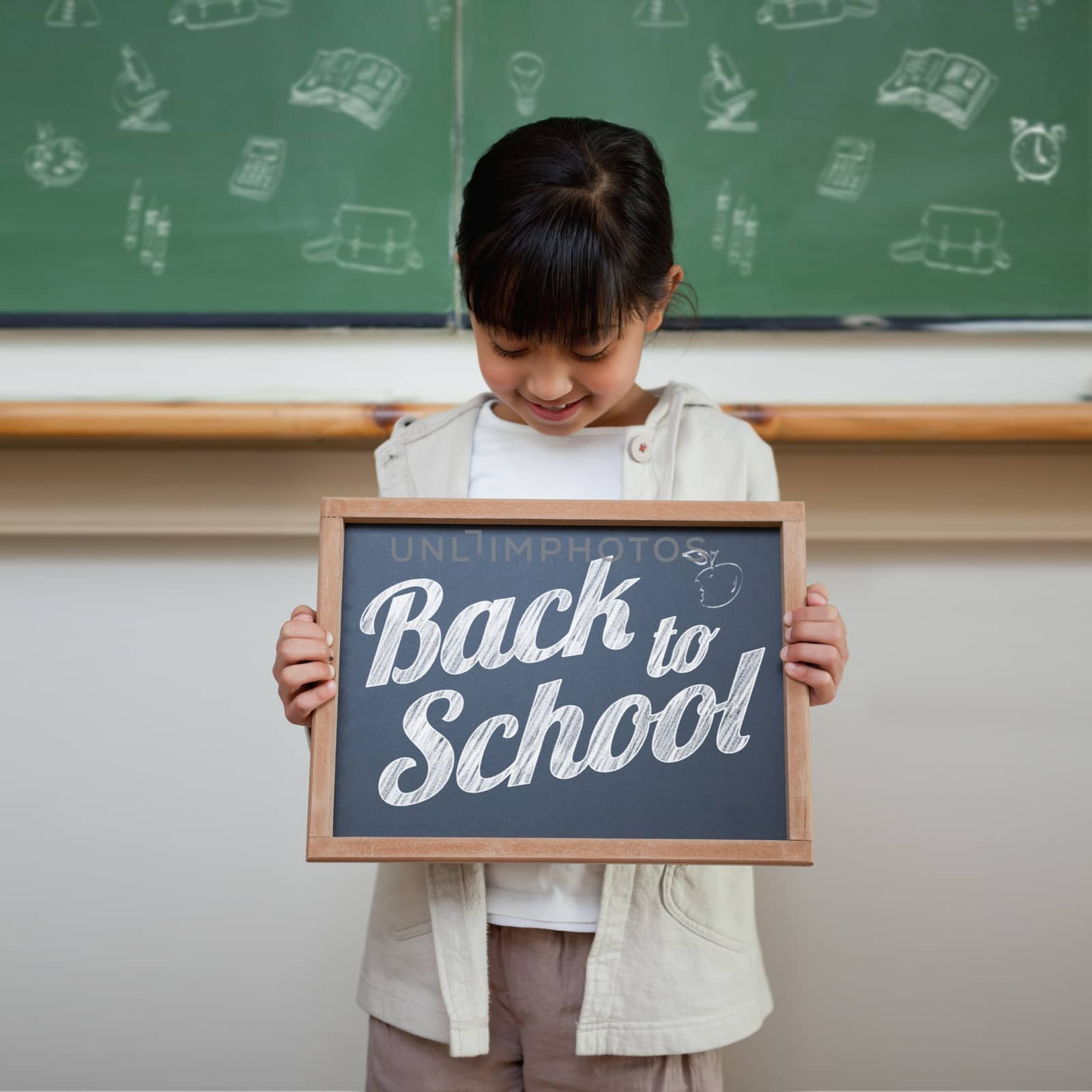 Back to school message against cute pupil showing chalkboard