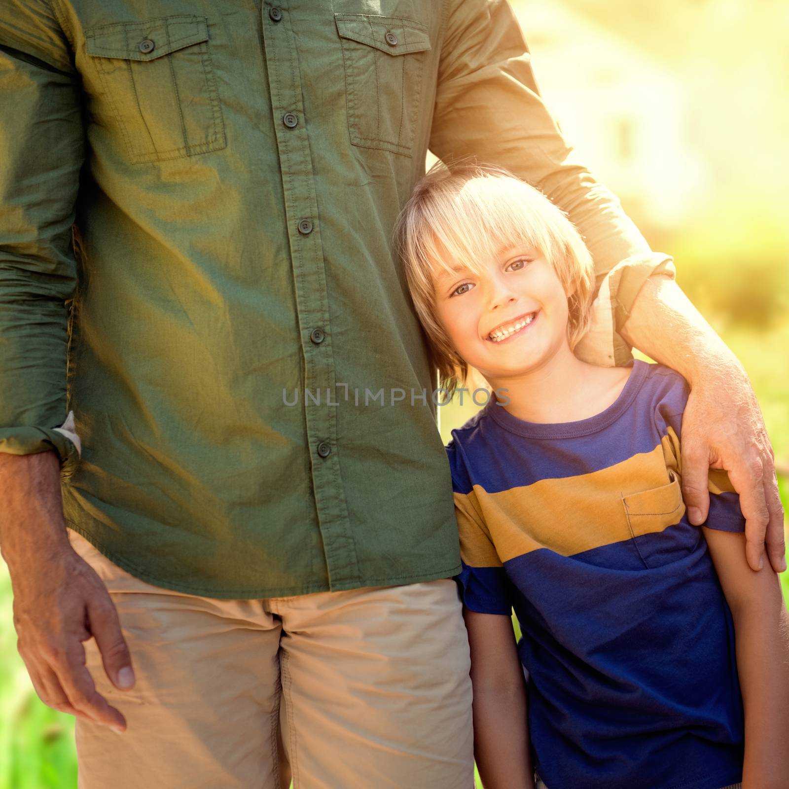 Portrait of a father with his son  against focus on home in a garden 