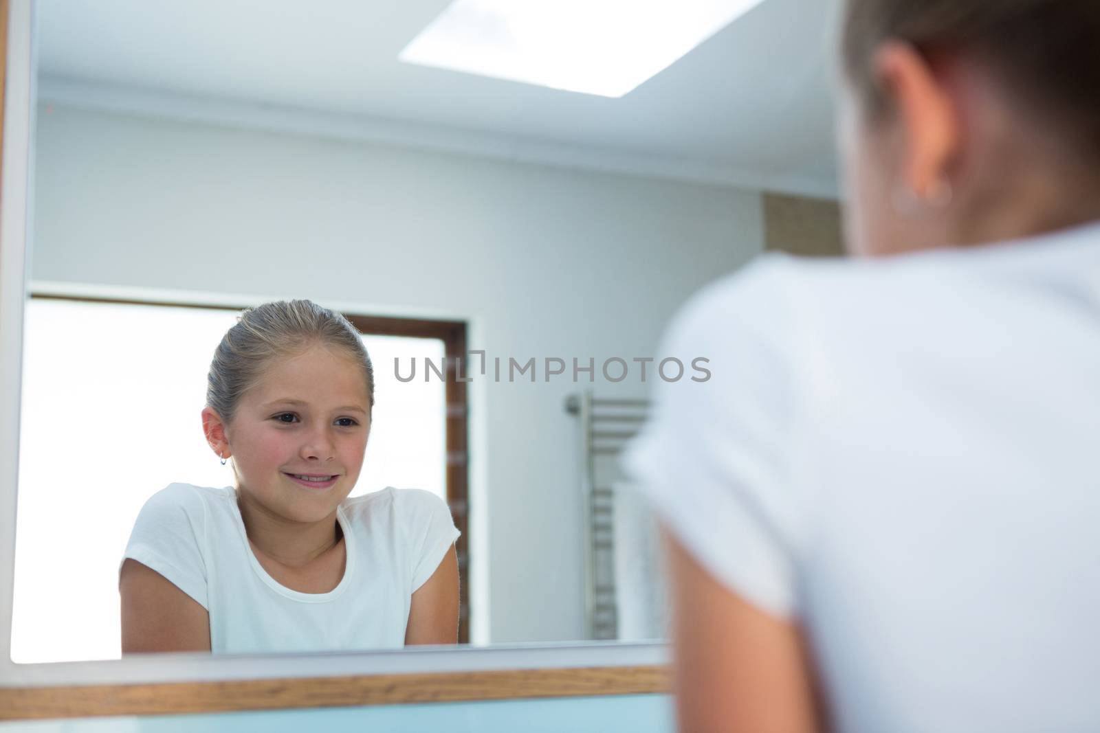 Girl looking in mirror by Wavebreakmedia