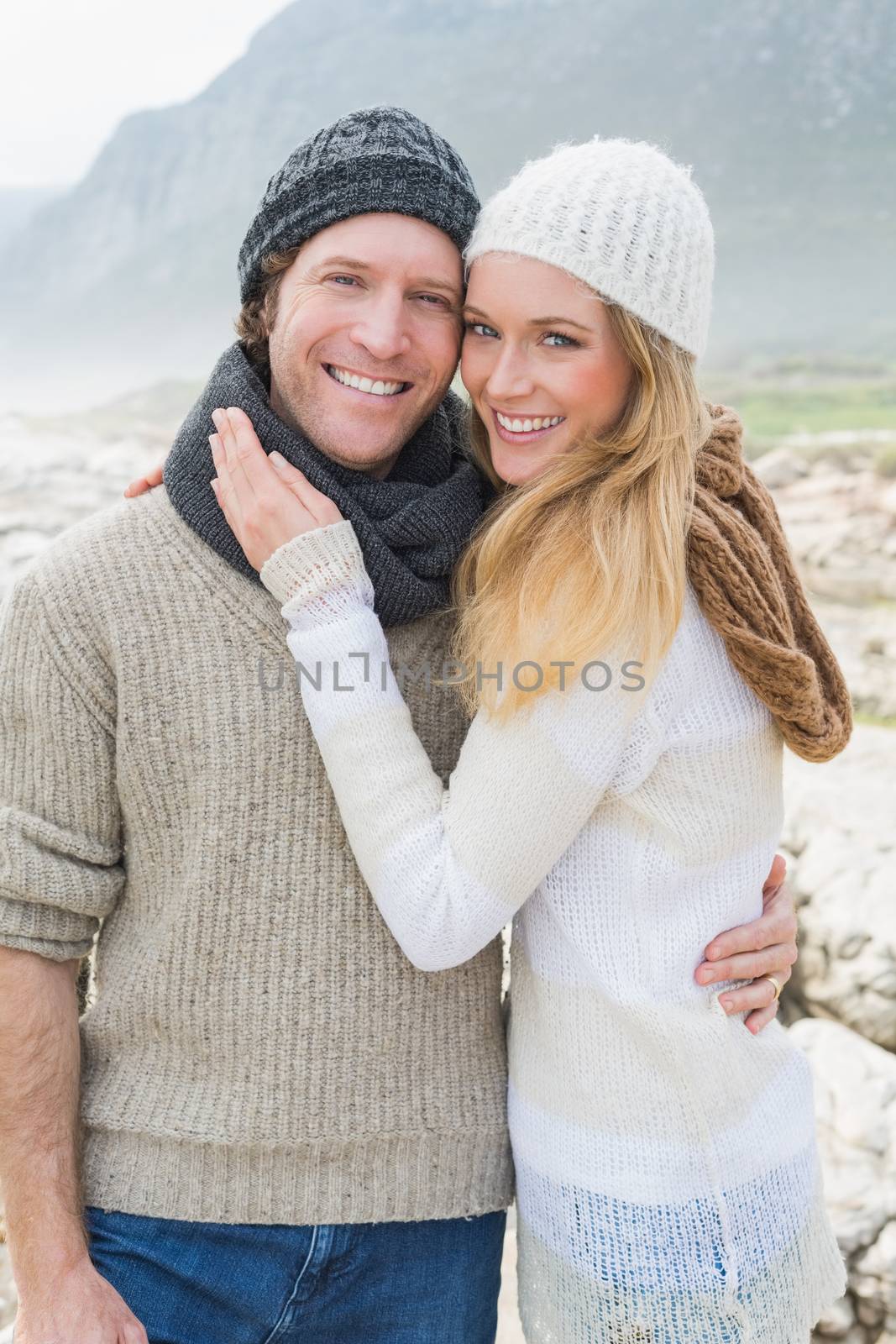 Portrait of a happy romantic young couple standing together on a rocky landscape