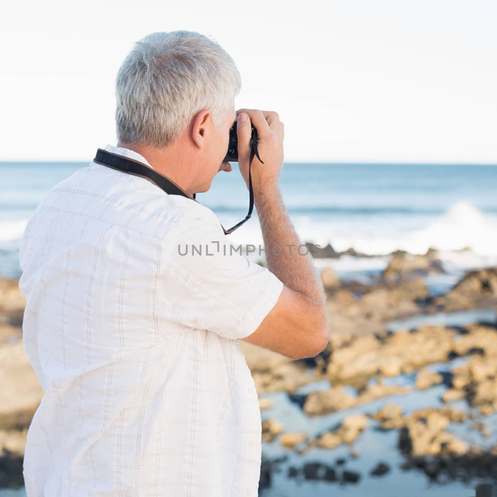 Casual mature man taking a photo of the sea by Wavebreakmedia