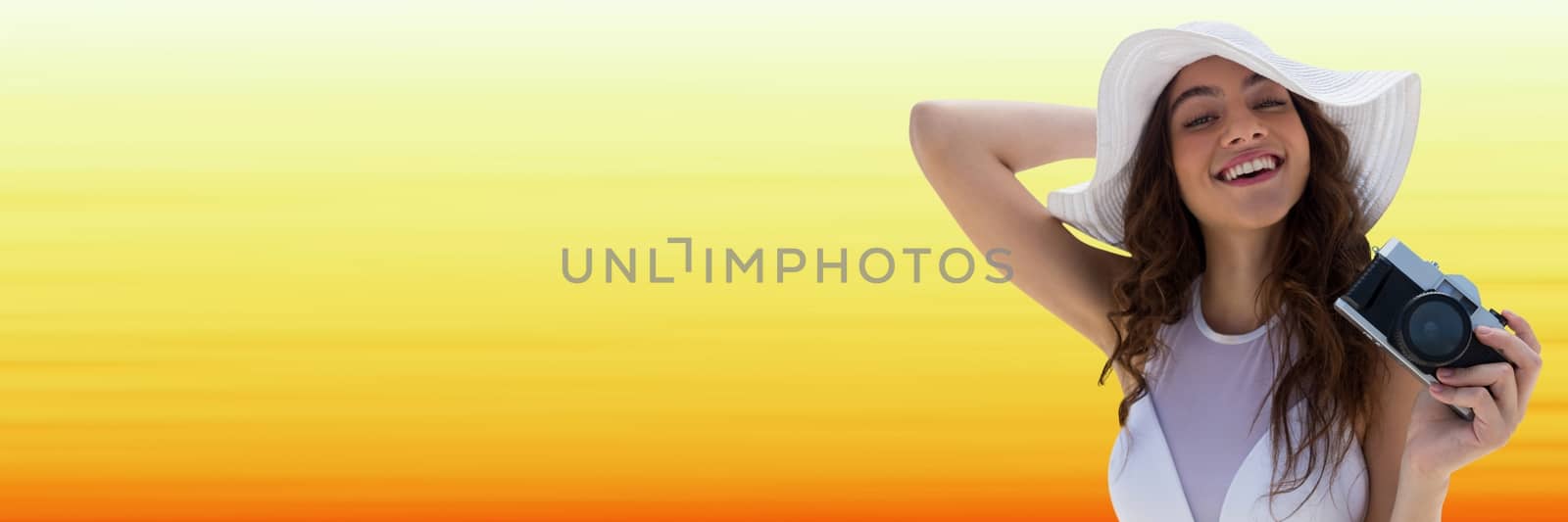 Digital composite of Millennial woman in summer hat with camera against blurry yellow background